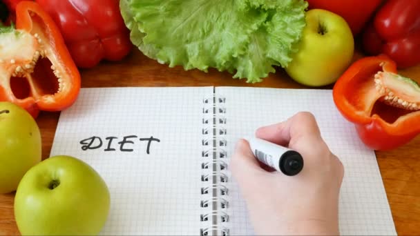 σημειωματάριο με σχέδιο διατροφής με φρέσκα λαχανικά και φρούτα στο τραπέζι, δίαιτα keto - Πλάνα, βίντεο