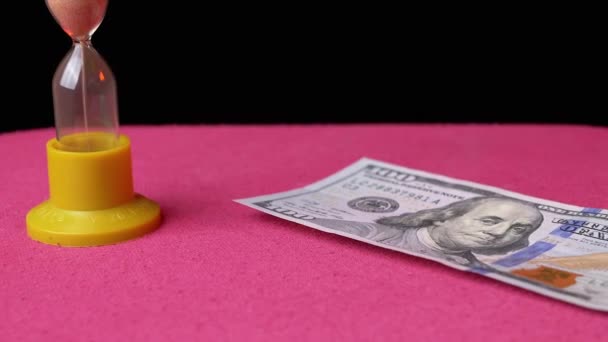 Spread Many 100 American Dollars on table with Sanduhr. Schulden rechtzeitig verschenken - Filmmaterial, Video