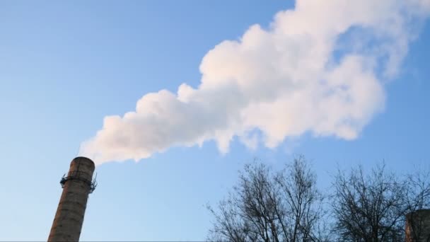 rurki instalacyjne z szarym dymem na niebieskim niebie, wieże zakładów chemicznych elektrowni jądrowej przeciwko błękitnemu niebu - Materiał filmowy, wideo
