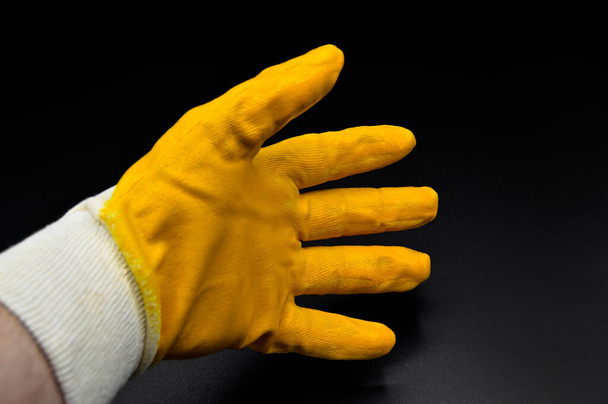 New and yellow protective work gloves isolated on black background - Photo, Image