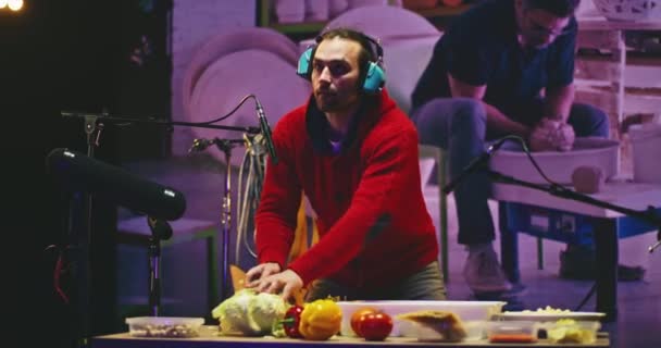 Mies jäljittelee keramiikka ääniä vihanneksia studiossa - Materiaali, video