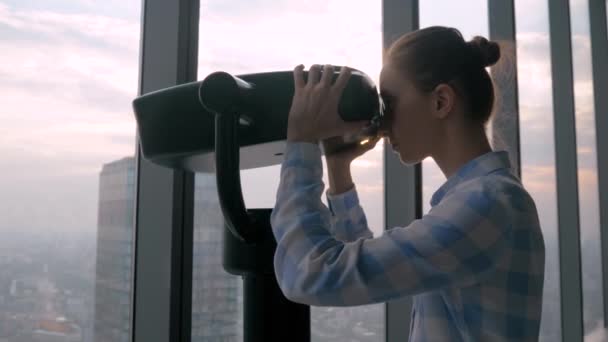 Wolny ruch - kobieta patrząca przez teleskop turystyczny i zwiedzająca pejzaż miejski - Materiał filmowy, wideo