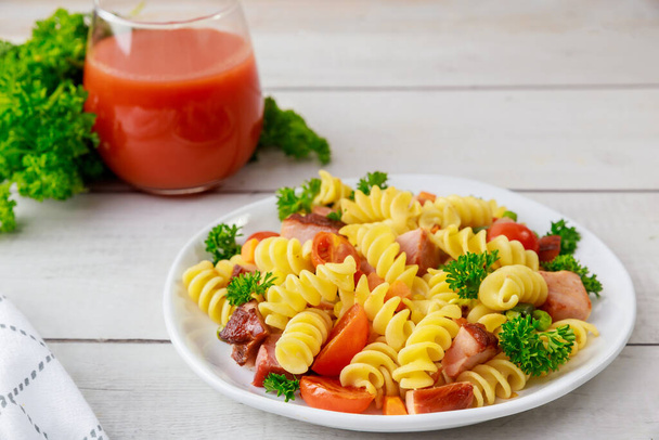 トマトジュースとイタリアのデュラム小麦パスタロティーニ。健康的な食事. - 写真・画像
