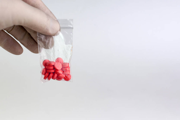 szintetikus kábítószerek vizsgálata: laboratóriumi technikus tart egy mintát egy új gyógyszer, könnyű háttér, rövid fókusz - Fotó, kép