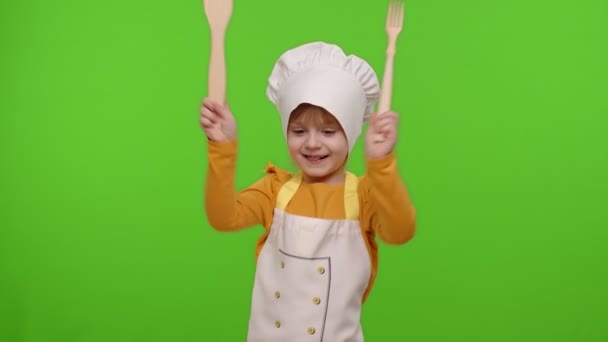 面白い子供の女の子の子供は、エプロンと帽子のダンスでコックシェフのパン屋を身に着けていました,周りを欺く,顔を作る - 映像、動画