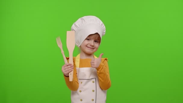 Niña cocinera cocinero panadero en delantal y sombrero sonriente, asiente cabeza de acuerdo en croma clave fondo - Imágenes, Vídeo