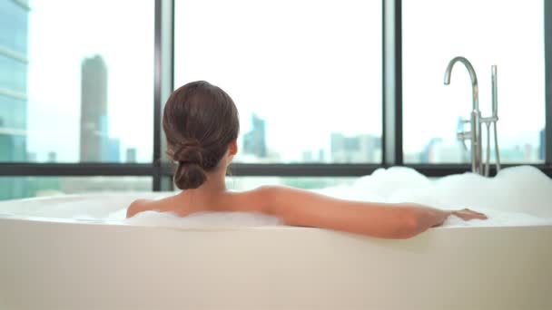 zdjęcia pięknej młodej azjatyckiej kobiety kąpiącej się przed oknem - Materiał filmowy, wideo
