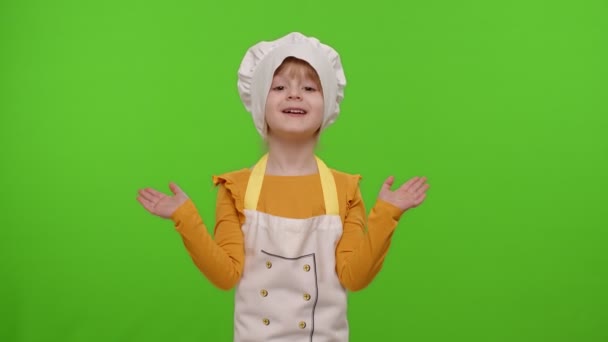 Chica vestida como chef cocinero apuntando a la derecha y a la izquierda en el espacio en blanco lugar para el logotipo de la publicidad - Metraje, vídeo