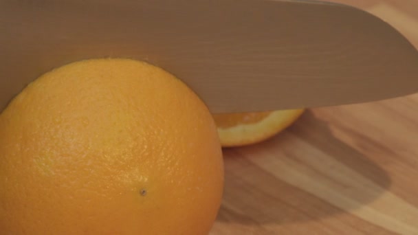 Woman is cutting orange into slices - Materiał filmowy, wideo