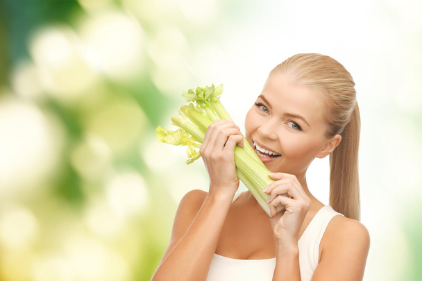 Woman biting piece of celery or green salad - Foto, Bild