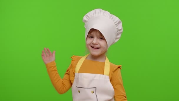Αστεία παιδί κορίτσι ντυμένος μάγειρας σεφ φούρναρης με ποδιά και καπέλο χορεύει, χαζολογάει, κάνει γκριμάτσες - Πλάνα, βίντεο