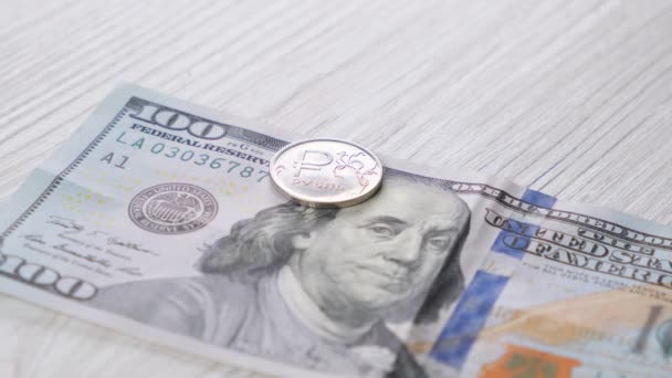 Moneda rusa de un rublo en un billete de cien dólares. Concepto de tipo de cambio. - Imágenes, Vídeo