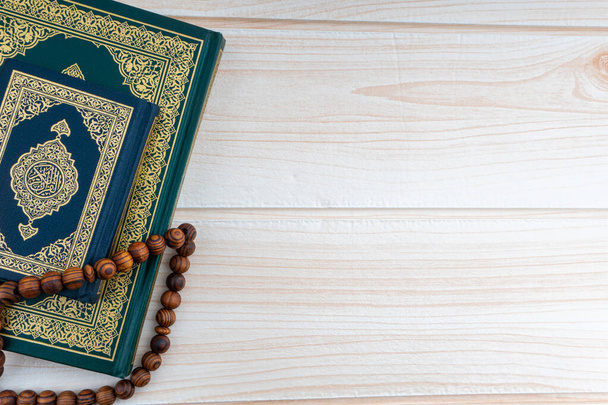 Sagrado Corán con caligrafías árabes traducción significado de Al-Corán y Rosario o Tasbih sobre fondo de madera. Ramadán, Hayy, Islámico y Copiar el concepto de Espacio - Foto, Imagen