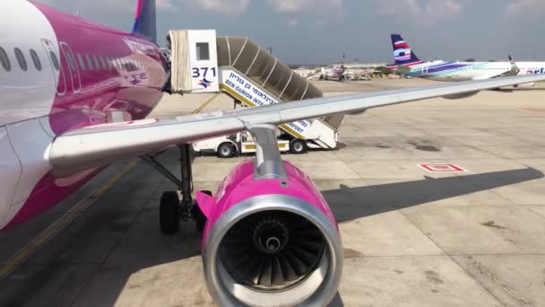 wizz air plane on Israel airport before take off, ben gurion airport, purple wing and boarding stairs plane - Filmagem, Vídeo
