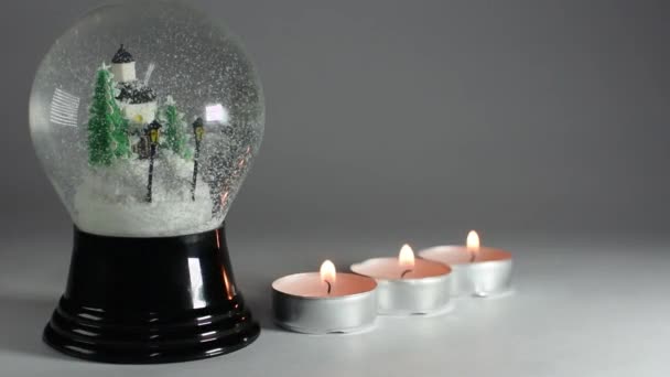 Schneekugel und Kerzen in einer Reihe Nahaufnahme - Filmmaterial, Video