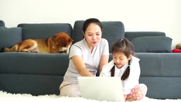 Mutter und Tochter, die im Wohnzimmer mit Shiba-Inu-Hunden Computer benutzen.  - Filmmaterial, Video