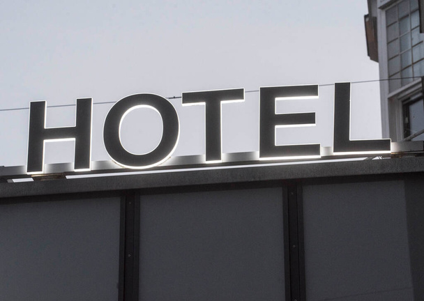 освітлений готельний знак біля входу в будівлю готелю
 - Фото, зображення