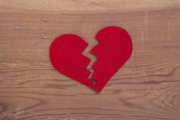 Red broken heart sign on wooden background. Broken heart, love and valentines day concept. - Photo, Image