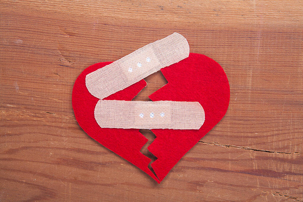 Rotes Schild mit gebrochenem Herzen auf hölzernem Hintergrund. Gebrochenes Herz, Liebe und Valentinstag-Konzept. - Foto, Bild
