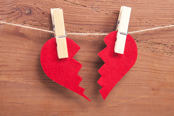 Red broken heart sign on wooden background. Broken heart, love and valentines day concept. - Photo, Image