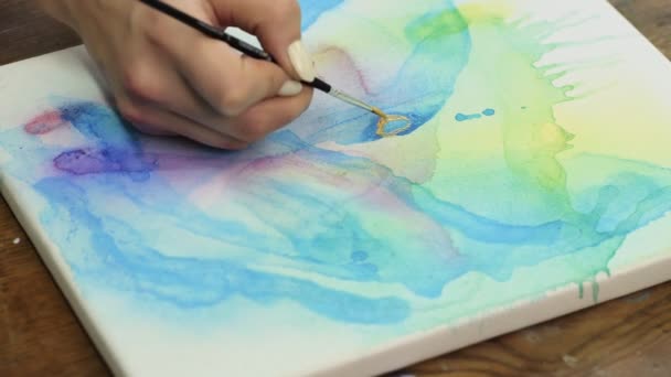 Arte fluido. Pintura colorida abstracta. Primer plano del artista utiliza pincel con pintura dorada para hacer cuadro abstracto - Metraje, vídeo