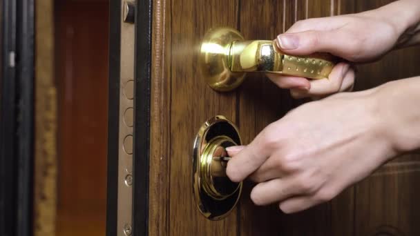Γυναίκα που χρησιμοποιεί ένα κλειδί για να ανοίξει την κλειδαριά της μπροστινής πόρτας - Πλάνα, βίντεο