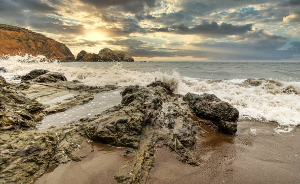 Rotsformaties tegen de achtergrond van de oceaan in het San Francisco Recreation Area, Rodeo Beach, California, USA. Kustlijn, prachtig landschap, Californische kust. - Foto, afbeelding