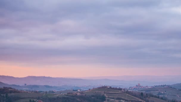Pôr-do-sol de lapso de tempo à noite: vinhedos famosos de Barolo no inverno, vila medieval de Serralunga d 'Alba no topo da colina, castelo iluminado ao anoitecer, céu dramático, Langhe Piedmont Itália - Filmagem, Vídeo