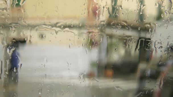 Gouttes de pluie sur verre avec fond urbain pluvieux hors foyer - Séquence, vidéo