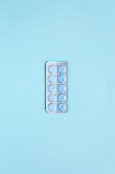 Male health. Blister with round blue pills on light blue background. Taking medicine. - Photo, Image