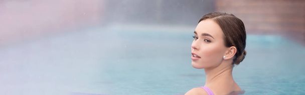 молода жінка дивиться геть і приймає ванну в відкритому гарячому весняному басейні, банер
 - Фото, зображення