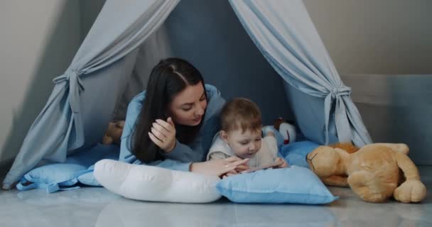 mère et petit enfant, jouant dans une tente dans la maison. Mouvement lent. - Séquence, vidéo