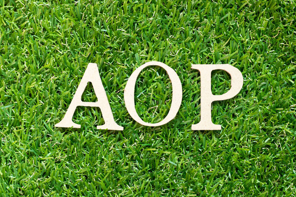 Αλφαβητικό γράμμα στη λέξη AOP (συντομογραφία του ετήσιου επιχειρησιακού σχεδίου ή του προγραμματισμού προσανατολισμένου στην οπτική γωνία) σε πράσινο φόντο χόρτου - Φωτογραφία, εικόνα