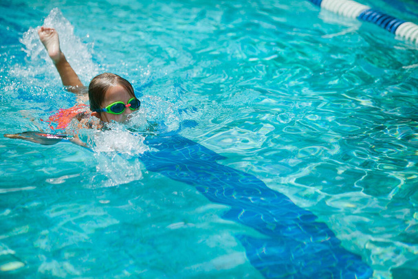Kislány úszás közben úszás leckék a helyi szabadtéri medencében nyáron - Fotó, kép