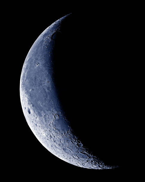 Πνιγμένη ημισέληνος Σελήνη με λεπτομέρεια κρατήρα στον γαλάζιο ουρανό. - Φωτογραφία, εικόνα