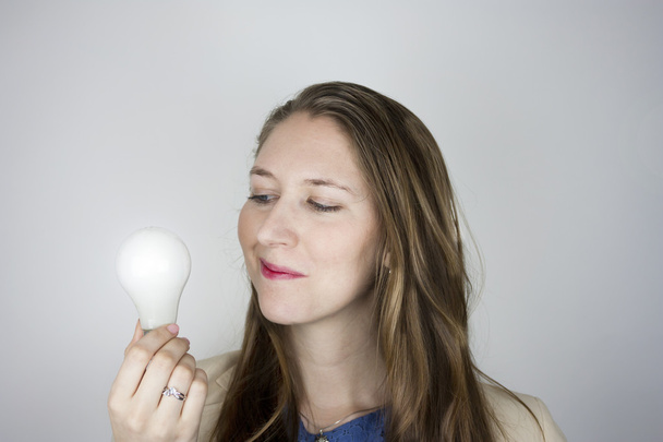 Business woman holding light bulb - Фото, изображение