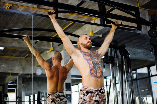 Back Arms Workout Athlet starke muskulöse Fitness tätowierter Mann athletischer Mann, der Muskeln aufpumpt  - Foto, Bild