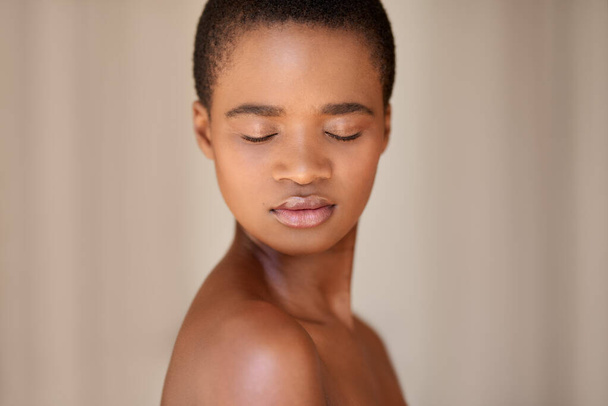 Mooie jonge Afro-Amerikaanse vrouw met kort haar en perfecte huid die 's morgens met gesloten ogen thuis staat - Foto, afbeelding