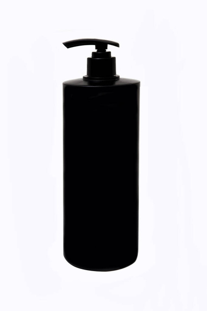 Черная пустая бутылка шампуня на белом фоне. - Фото, изображение