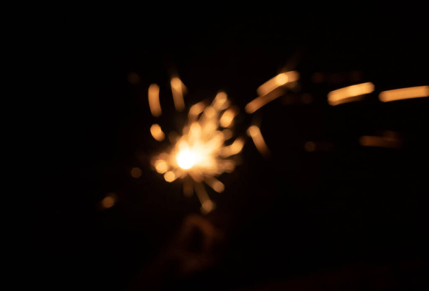 Тьмяні іскри з вогню перед чорним тлом
 - Фото, зображення