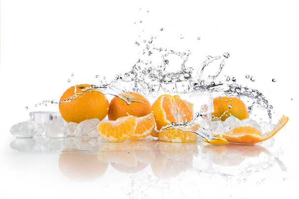 mandarinky na bílém pozadí, vodní stříkance, rozdrcený led, kostky ledu - Fotografie, Obrázek