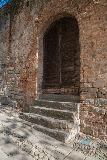 Мбаппе деревянной двери в средневековой деревне Монселиче в сторону замка и променада в сторону святилища семи церквей в летний день, Падуя, Италия. - Фото, изображение