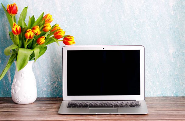 Oficina o espacio de trabajo en casa con ramo de tulipanes de colores en la mesa. Espacio de trabajo femenino - Foto, imagen