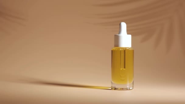 Serum in glazen fles op beige ondergrond. Aromatherapie olie. Natuurlijke cosmetica. - Video