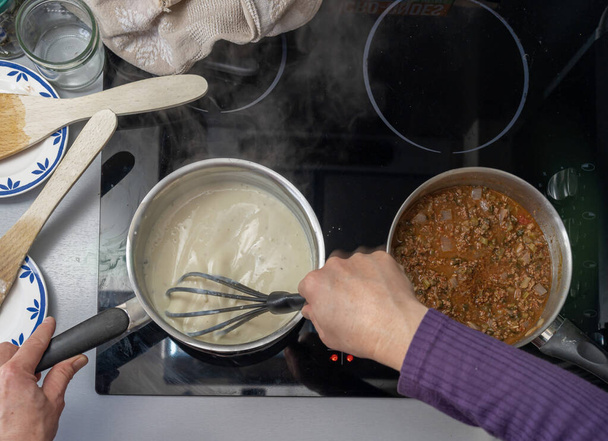 Paryż, Francja - 02 14 2021: Przygotowanie lasagne z mięsem, szpinakiem, pomidorami i beszamelem - Zdjęcie, obraz
