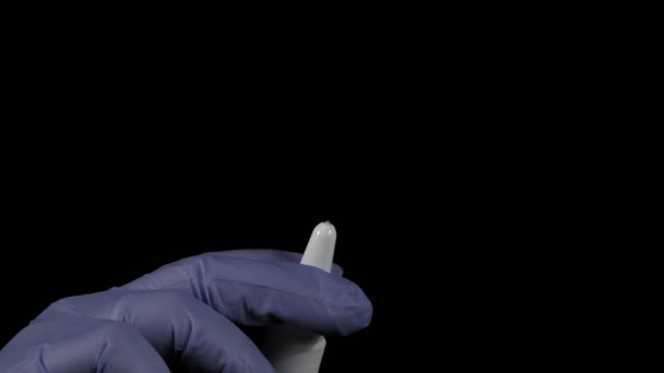 The hand in the medical glove holds the spray and injects. - Footage, Video