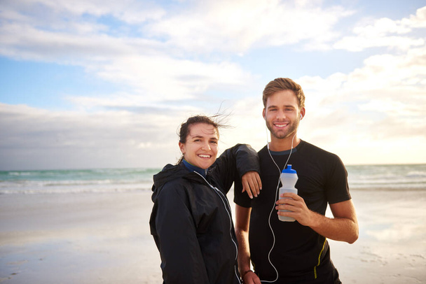 Retrato de amigos masculinos y femeninos listos para una carrera de playa por la mañana - Foto, Imagen