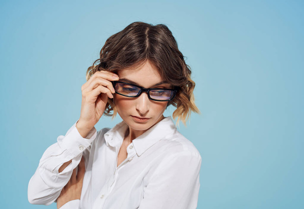 Fashionable woman curly hair short haired glasses and white shirt blue background - Foto, immagini