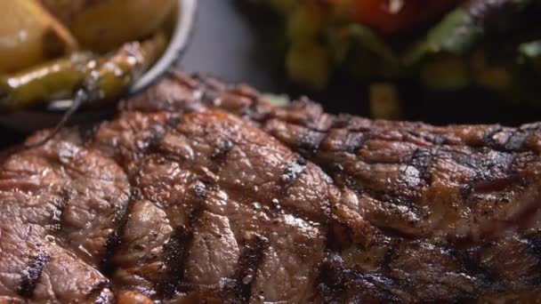 Gegrild vlees, salade en geroosterde uien en chili pepers op bord - Video