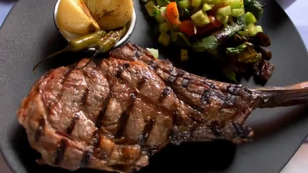 Gegrild vlees, salade en geroosterde uien en chili pepers op bord - Video